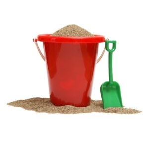a red bucket full of sand with a green shovel