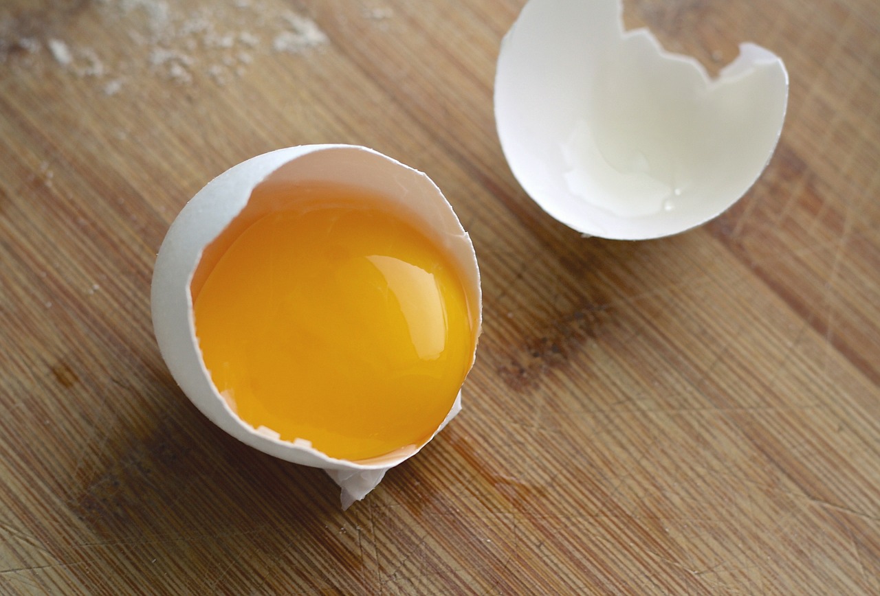 an egg on a cutting board with the yolk still inside