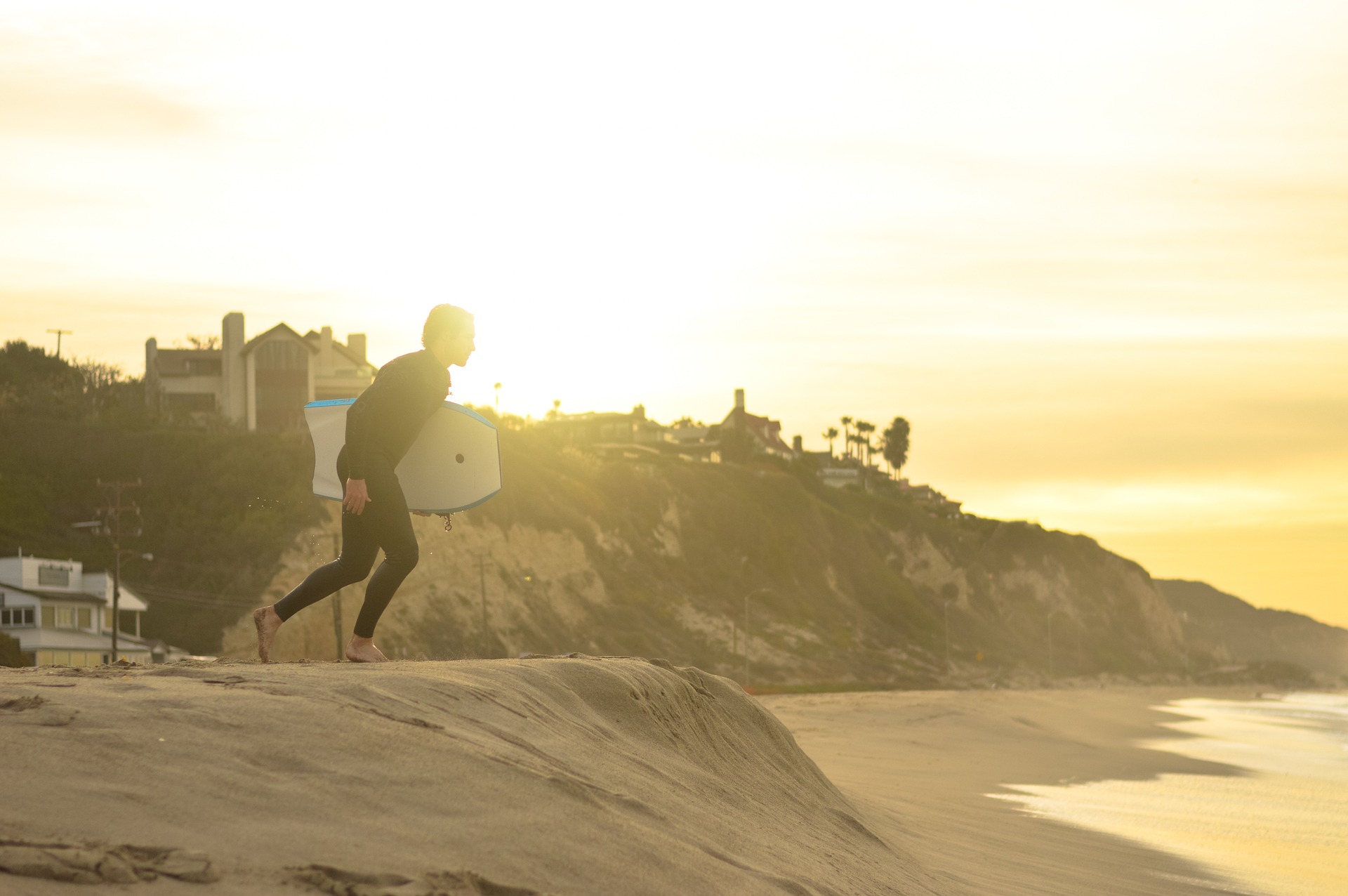 body boarder running into the waves early in the morning