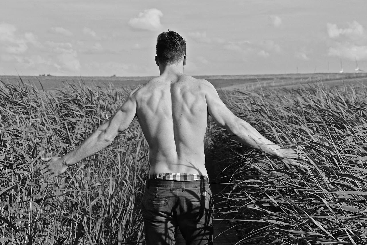 muscular man walking through a field