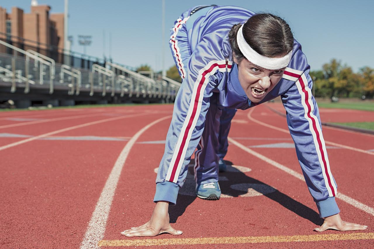 woman in a tracksuit in sprinting position